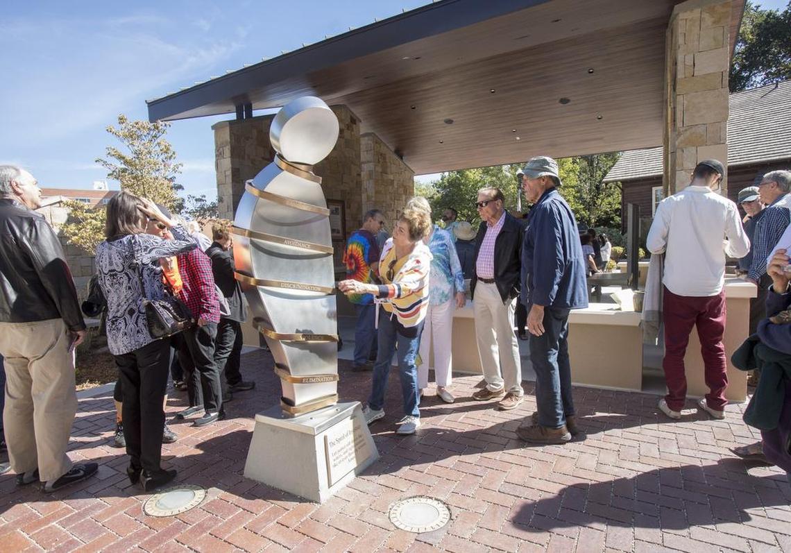 The words “language, avoidance, discrimination, violence and elimination” are enscribed on “The Spiral of Injustice,” designed and fabricated by Ken McCall. The words are inscribed in six languages around the figure. “I just love this sculpture,” says Sondra Hackborn, in center. “If you see discrimination, speak out. Don’t keep quiet.” The sculpture was unveiled Thursday during the dedication of the Marilyn Shuler Classroom for Human Rights at Downtown Boise’s Anne Frank Human Rights Memorial.