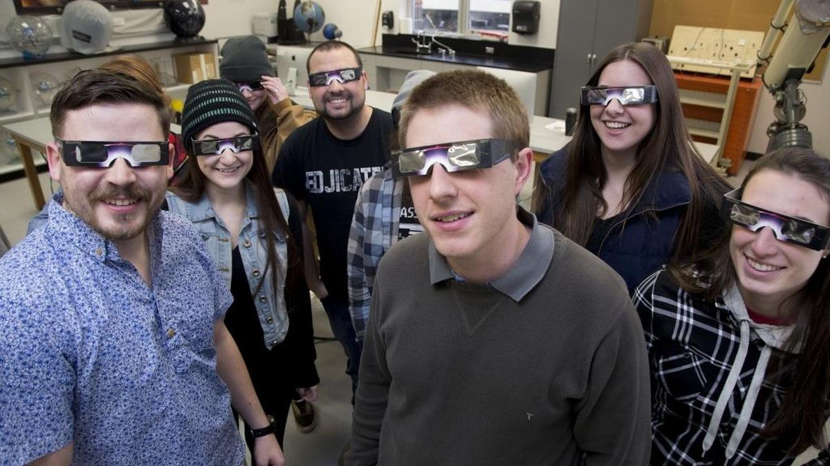 Boise State Prof. Brian Jackson and students in his Physics 205 Stellar Astronomy class don protective sunglasses for viewing a solar eclipse.