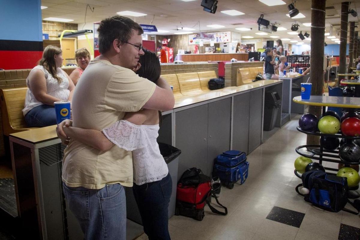 Cody Swinnerton, 18, gives his girlfriend, Ashleigh Lethcoe, 19, a hug while bowling for the last time at 20th Century Lanes last June 30, the 57-year-old business’s final day.