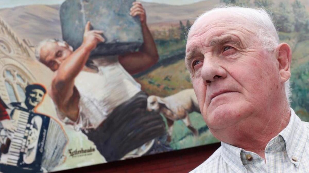 José Luis Arrieta, once the U.S. champion Basque weightlifter, stands in front of his image in the mural on the Basque Block in Downtown Boise in 2010. Arrieta died in 2017.