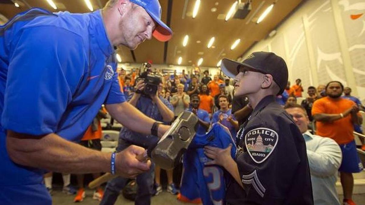 Rashid, who was officer for a day with Boise Police Department, returns the Bronco hammer to the football team.