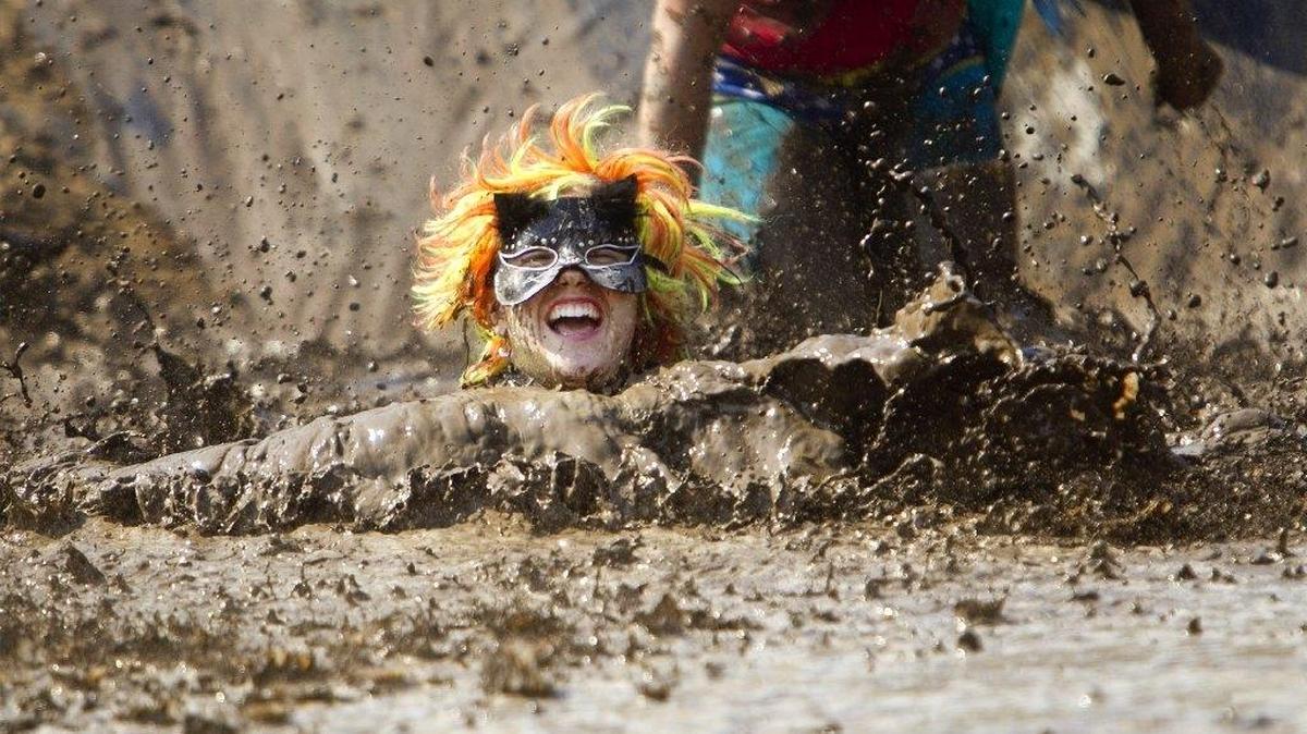 Pheena Berwick of Nampa leaps into a large muddy pit near the finish line of the Dirty Dash at Bogus Basin in August 2013. This year’s mud run will be held in October because of perceived fire danger.