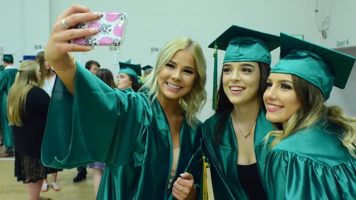 Borah High School seniors Kimber Nelson, Rena Montesano and Hailey Fleming pose for a selfie moments before the school’s 2016 Commencement Tuesday at Taco Bell Arena.