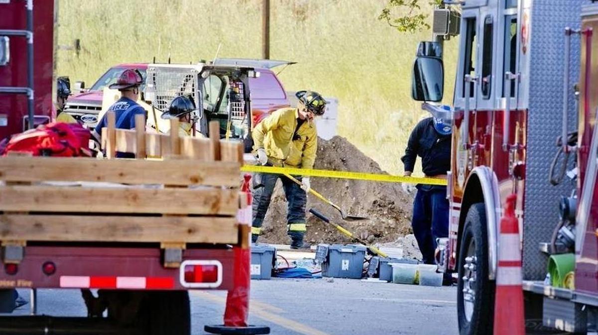 A firefighter with the Boise Fire Department digs near the scene of a trench collapse on North Gary Lane near the intersection of North Hill Road Parkway Tuesday evening. Three people were reported to have been trapped, and two are reported dead.