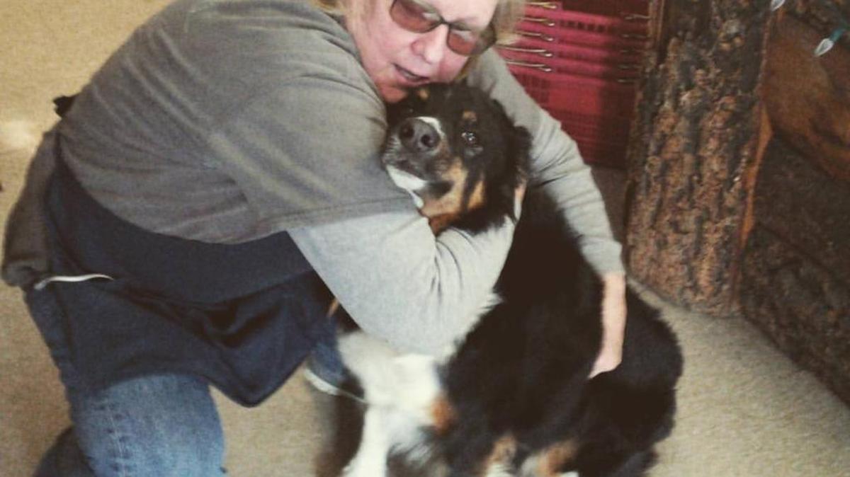 Rosie Brower, a worker at the Hilltop Station restaurant, hugs Wrosco the dog on Sunday after the canine was found days after a traffic accident. “He’s not my dog, but he’s my dog,” Brower said of the dog she rescued from an animal shelter and later provided to the dog’s current owner, John Evans.