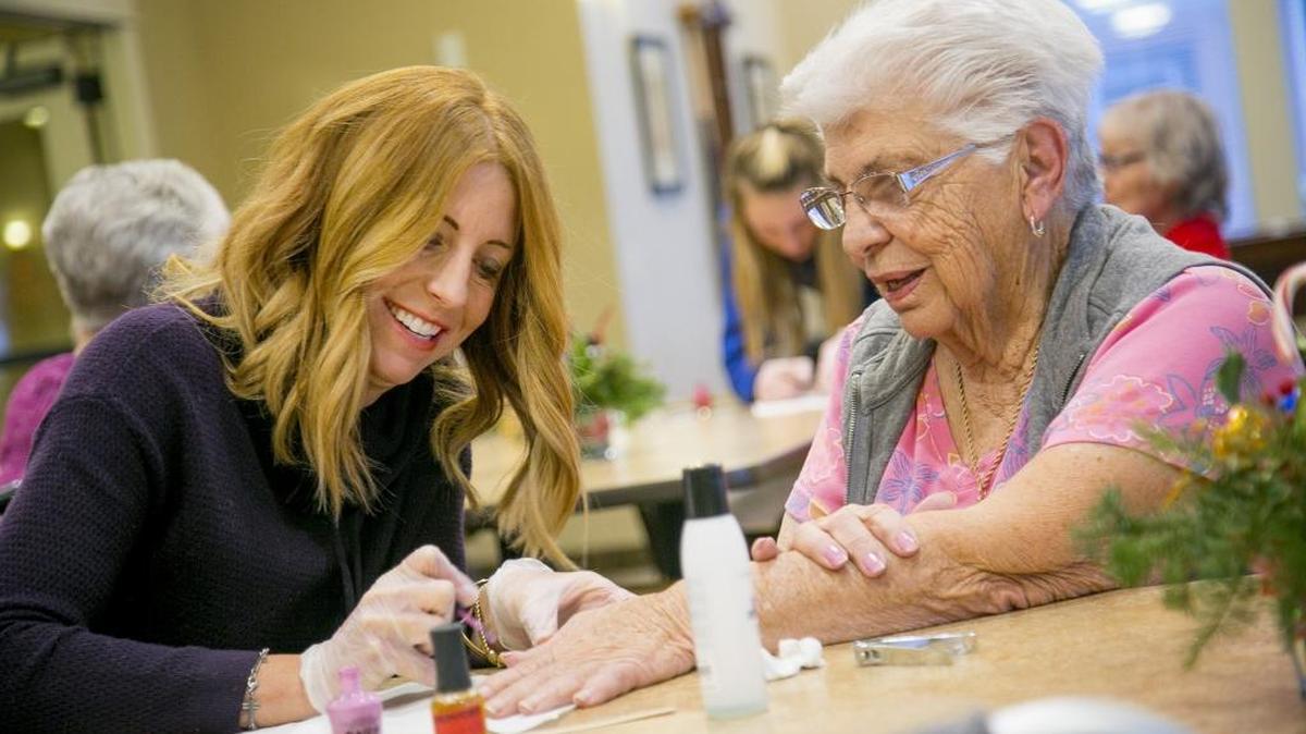 Amy La Jocies paints the nails of Gloria Farris at Grace Assisted Living in Boise. La Jocies and her daughter, Ashley, have been visiting the center one day a week since June.