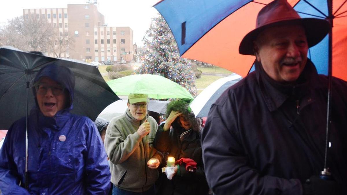 About 100 people stood on the steps Sunday evening to show their support to refugees.