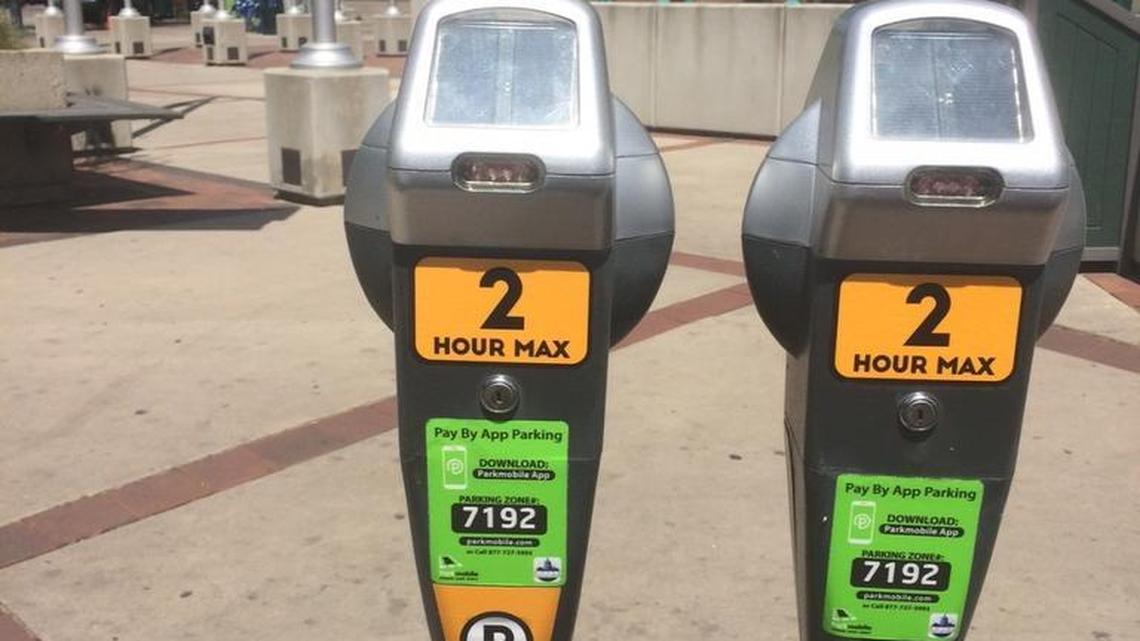The orange stickers on these meters mean the cost to park in front of them is $1.50 for the first hour and $2.50 for the second hour.