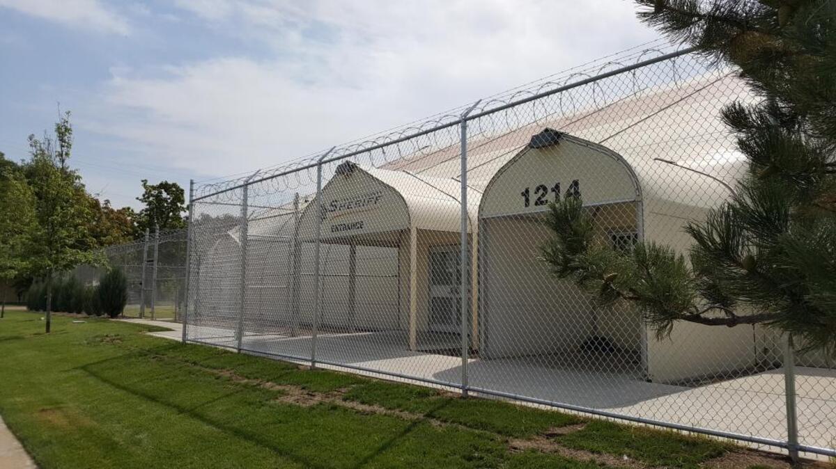 Canyon County finally finished some of the jail tent facility’s security improvements. Improvements included the installation of an expanded metal lid over the kitchen area, a secure exterior door leading from the kitchen outdoors, a lid over the recreation yard, and a 10-foot perimeter buffer fence with concertina wire that encloses most of the tent jail.