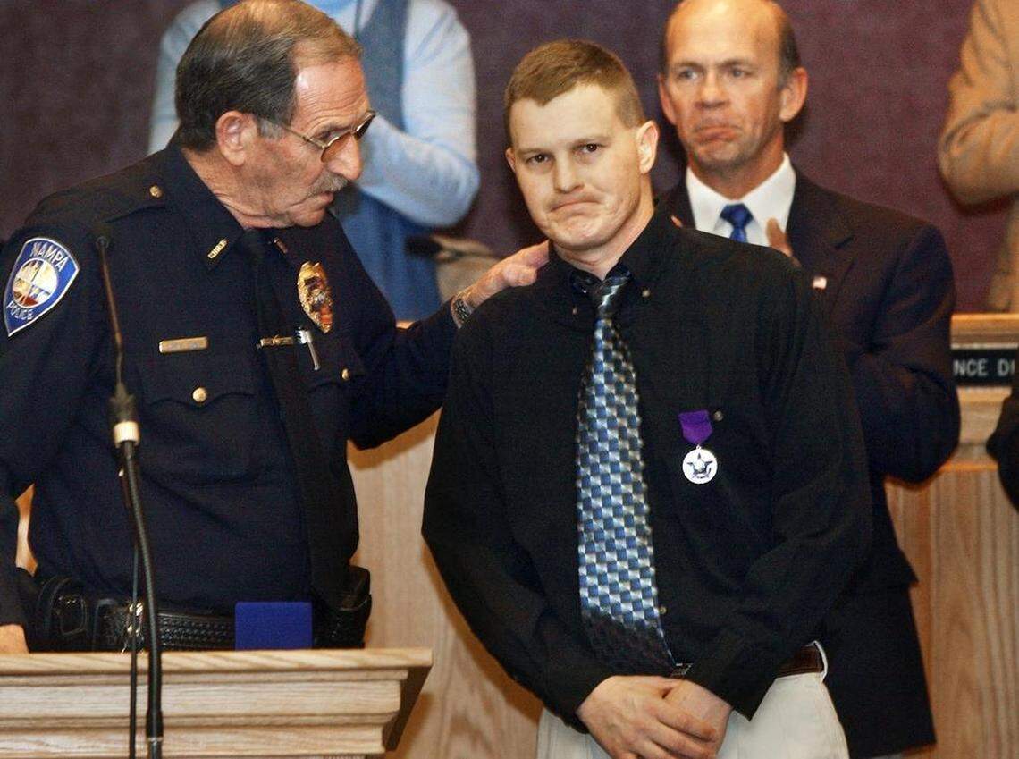 Cpl. Allen Williamson receives his Purple Heart medal Monday from Nampa Police Chief Curtis Homer.
