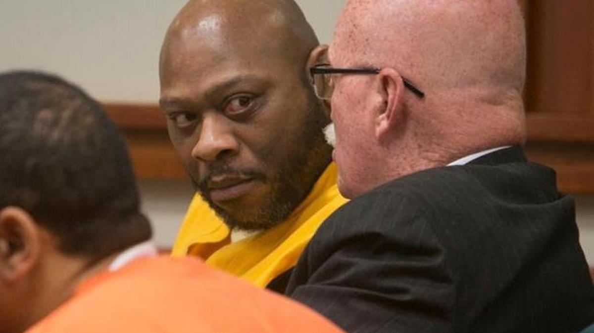 John C. Douglas, center, speaks with defense attorney Jack McMahon during a hearing last year.