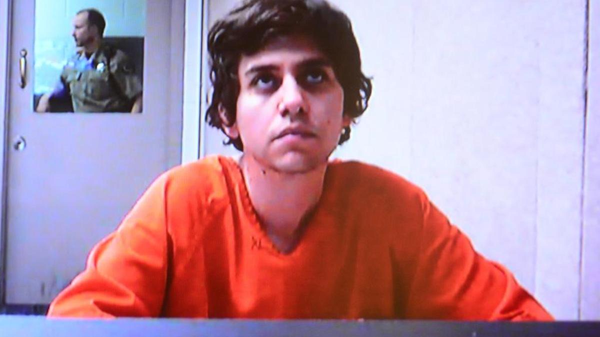 Michael Downs listens to Ada County Magistrate James Cawthon during a video arraignment broadcast to the Ada County Jail from the county courthouse. Downs is charged with felony aggravated battery and use of a deadly weapon in commission of a crime.