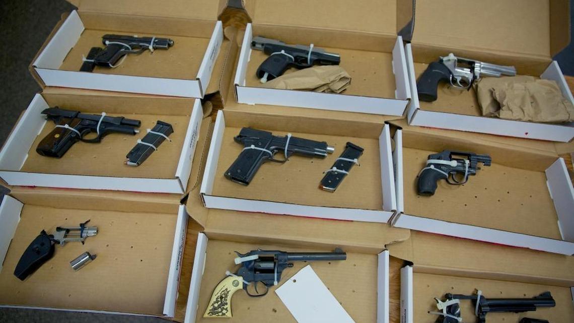 In this Dec. 9, 2013 file photo, firearms evidence is on display during a news conference in Portland, Ore. Oregon lawmakers passed a bill last year that makes it easier for police to take guns away from people convicted of domestic violence. Among other things, the state law makes it possible for local police to confiscate the guns.