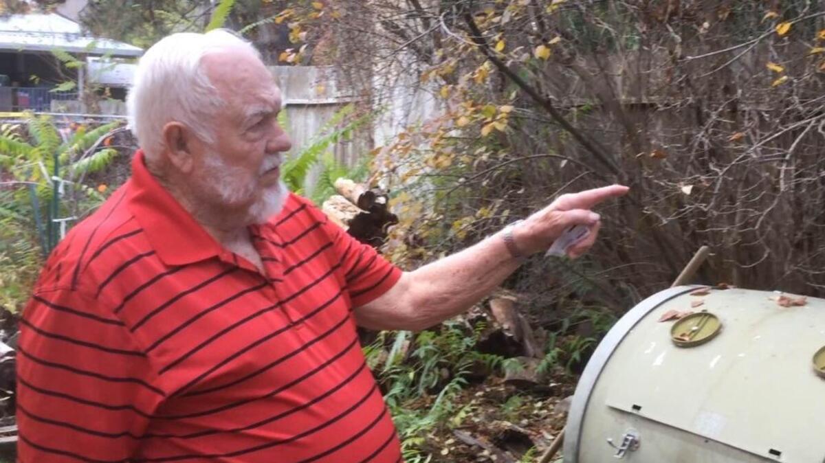 Jack Garrett, 83, who has lived in the Central Rim neighborhood about 50 years, points to the 6-foot fence that a man fleeing police jumped Friday afternoon. Garrett’s neighbor, Mrs. Lenz, saw the man jump into his yard, and he found footprints in a pile of grass that he believes were left behind when the man jumped a fence into a third yard.