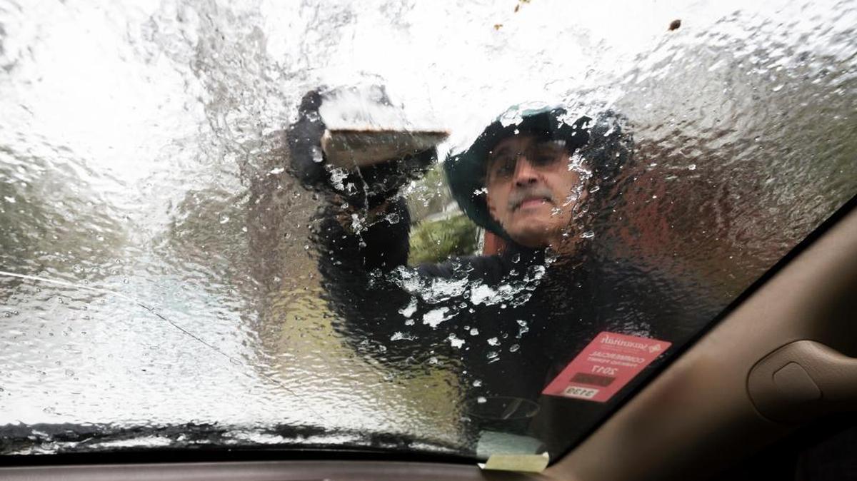 A Georgia driver scrapes ice off his windshield that accumulated overnight from freezing temperatures Jan. 3 in Savannah.