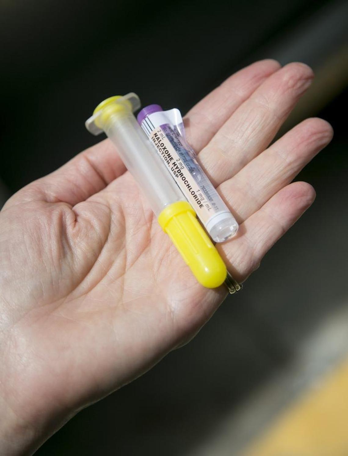 A paramedic holds a dose of naloxone, used to reverse the effects of opioids in an overdose situation.