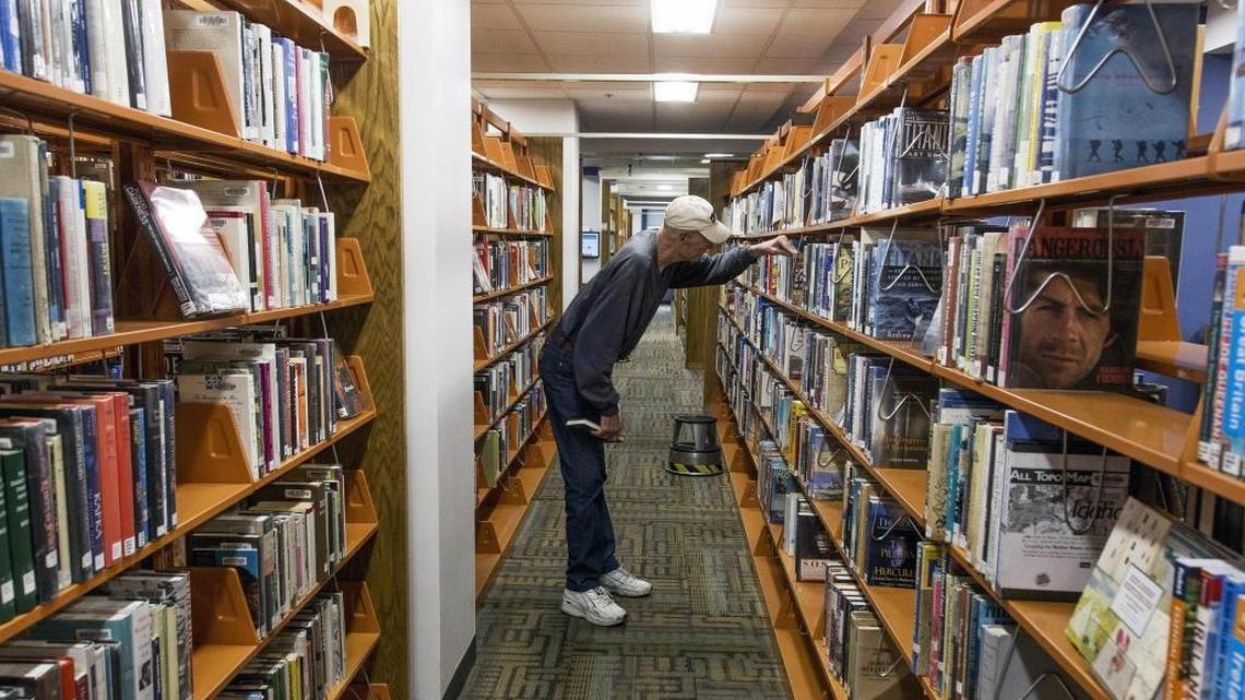 Jim Sprouls browses for books on the second floor of the Boise Public Library in Idaho. The Berkeley Public Library in Northern California recently announced it would do away with late fees for books and other materials, such as CDs.