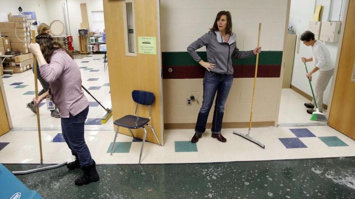 Trail Wind Elementary School Principal Beverly Boyd, center, and Assistant Principal Jean Lovelace, right, joined teachers, staff and Boise district maintenance staff Jan. 9 to clean up classrooms and hallways after fire sprinkler pipes burst.