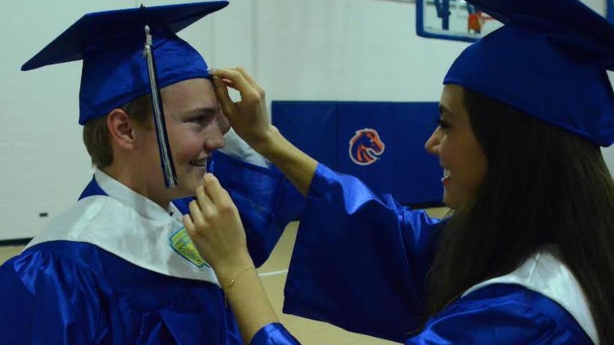 Payton Ball gets some help from classmate Olivia Clark as they prepare for Timberline High School’s graduation ceremony Tuesday evening at Taco Bell Arena. They were among 353 graduates at Timberline.