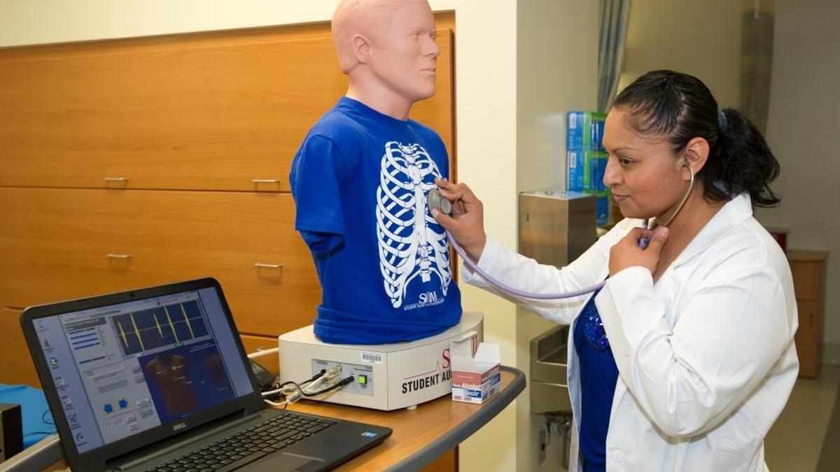 Boise State adult gerontology nurse practitioner student Jennifer Valdez examines a mannequin in the school’s health sciences simulation center. Students in nursing specializations use the center to learn and practice health-care procedures.