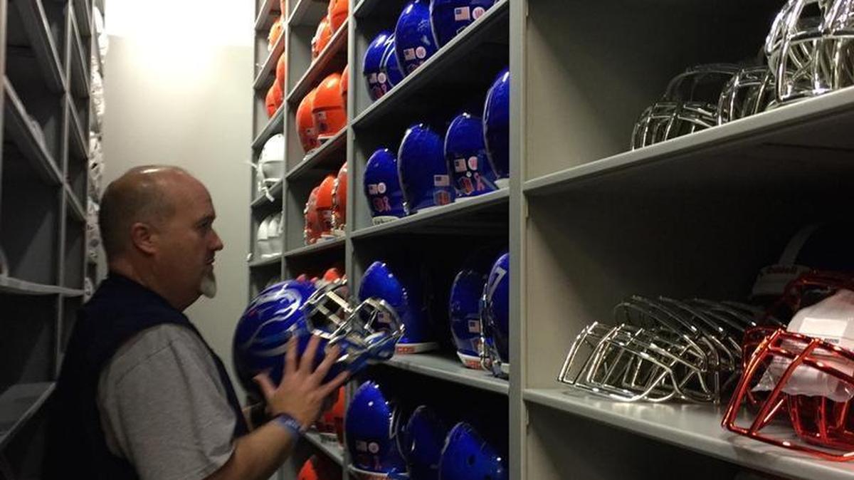 Dale Holste, Boise State University’s certfied athletic-equipment manager, between sliding storage cabinets.
