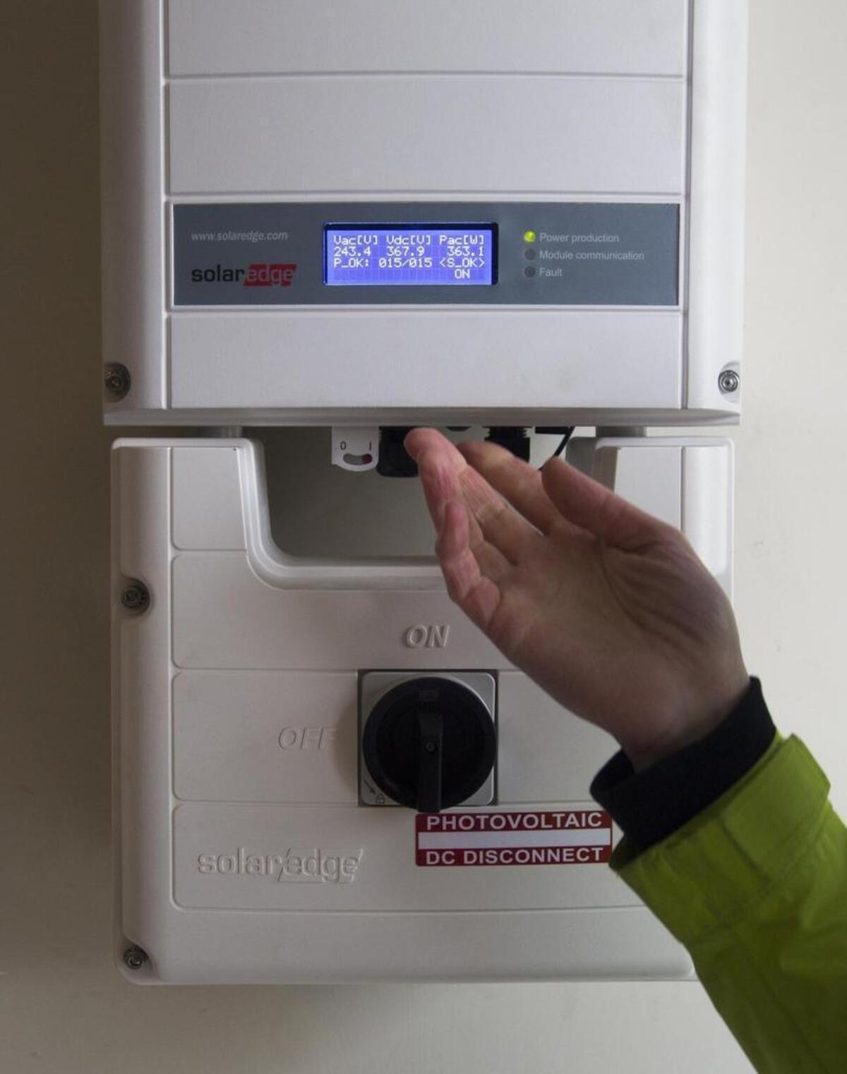 Direct-current electricity from rooftop solar panels is routed to this inverter in an East Boise home for conversion into household alternating current.