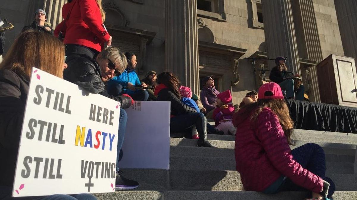 Protesters sit on the steps of the Idaho State Capitol building prior to the Women’s March on Sunday, Jan. 21.