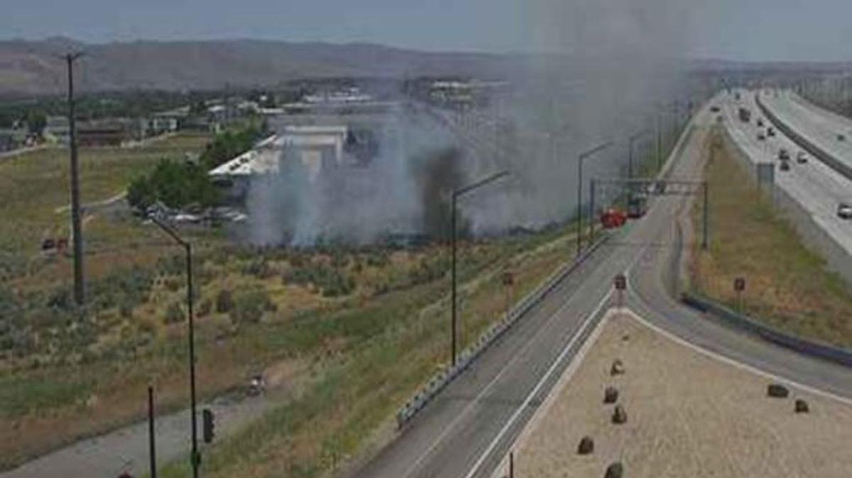 A traffic camera shows smoke rising from a brush fire near the Broadway Exit on westbound Interstate 84 on Monday afternoon.