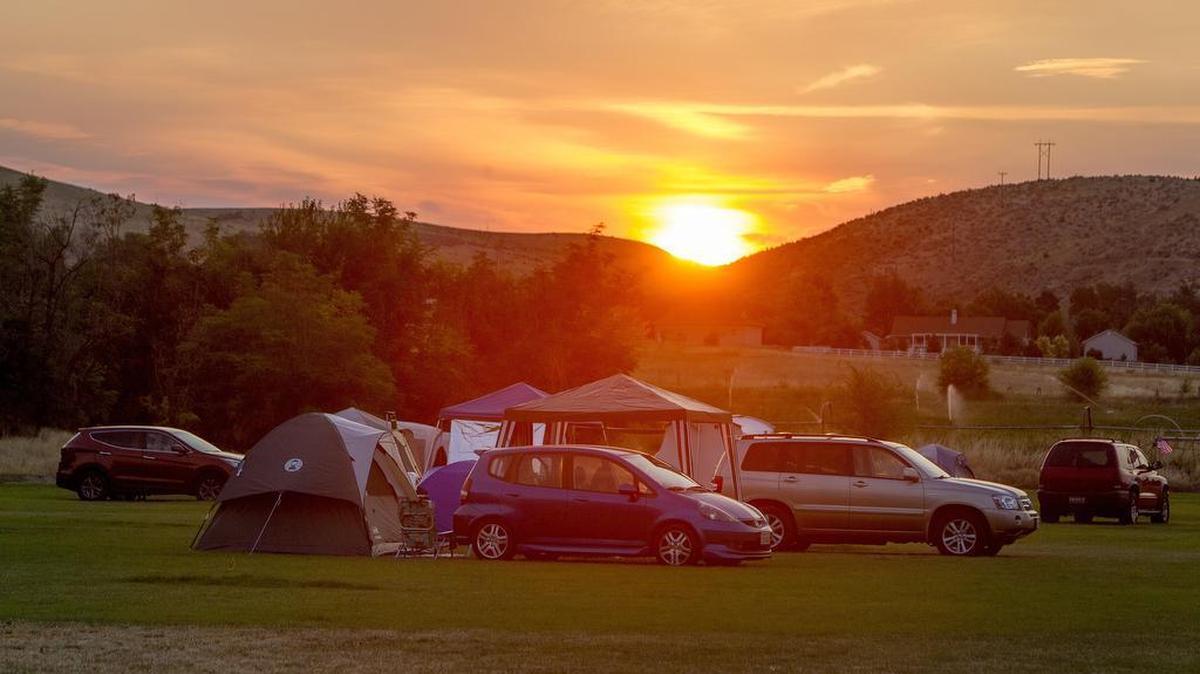 The sun rises over a soccer field behind Weiser High School, which has been converted to a campground for the solar eclipse. About 250 tent spaces have been sold for the Monday event.