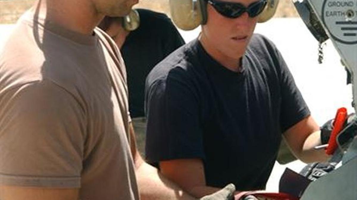 Staff Sgt. Nathaniel Kibodeaux (left) and Airman 1st Class Stacy Wilson remove weapons pins from an A-10 Thunderbolt II storage compartment in an undated photo from the U.S. Air Force.
