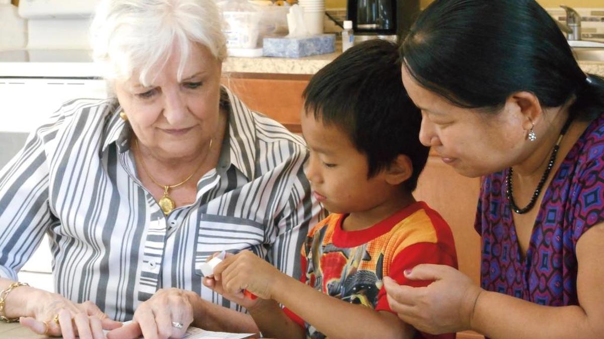 Learning Lab volunteer Loreen Todd helps new Boise residents and Bhutanese refugees Anjal and his mother, Sanchu. Sanchu is learning to coach Anjal as he learns the English alphabet. The Learning Lab brings classes to their Boise apartment complex, targeting residents who might otherwise lack access to Learning Lab’s services.