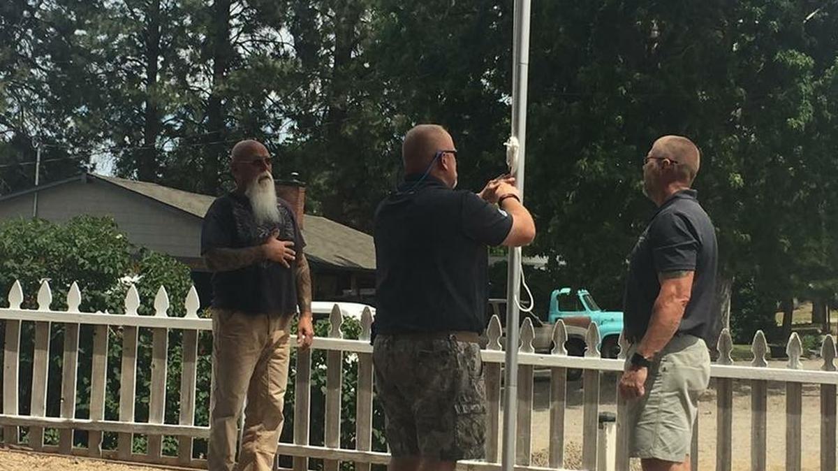 Jamie Popwell, right, and Brantley Cargill, center, of Flags for Vets install a flagpole, flag and solar light kit on Saturday, July 1, to honor the service of U.S. Marine Corps veteran Larry Clemens, left.