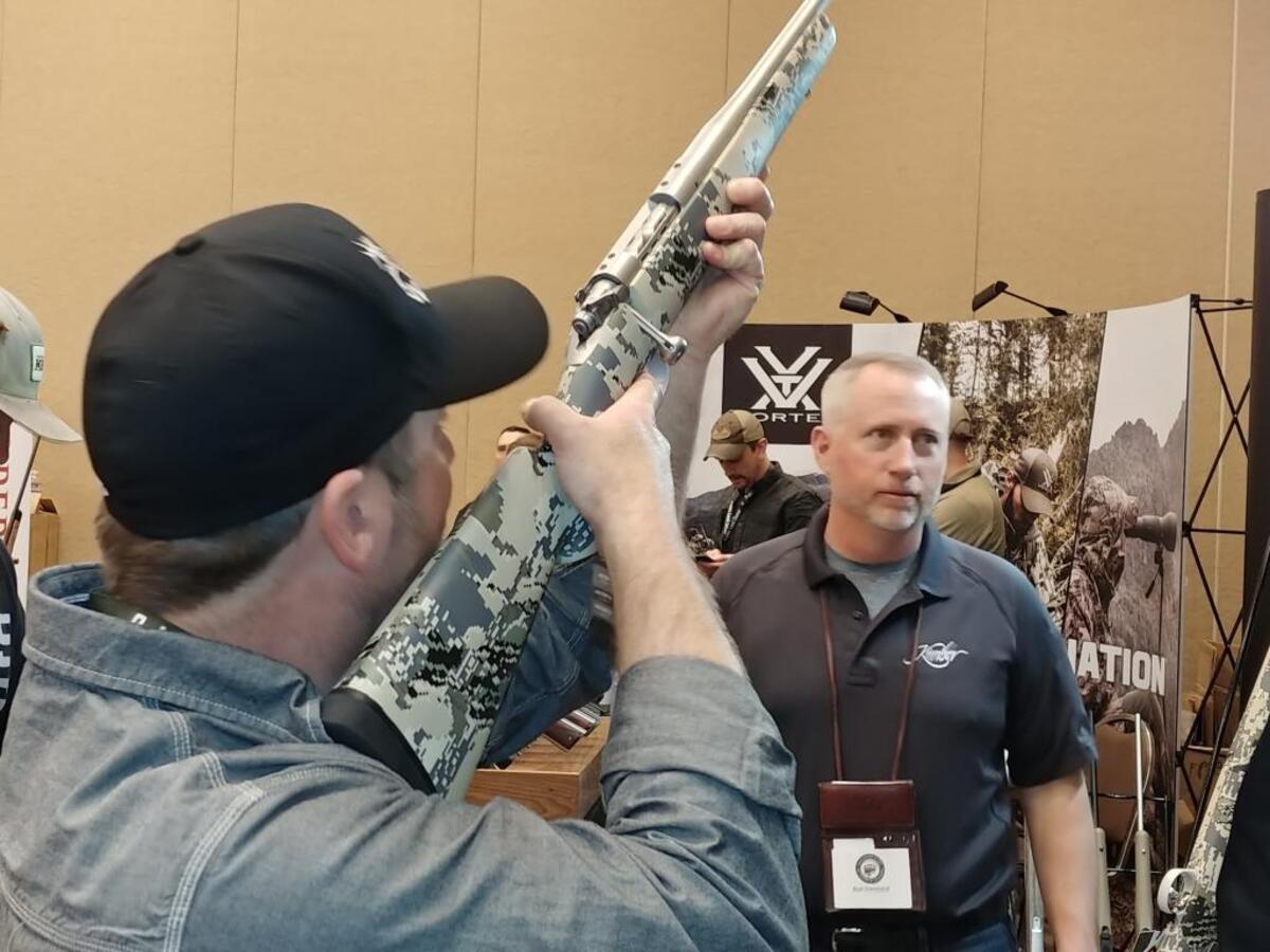 Clint Engebretsen of Granite Falls, Montana, checks out the feel of a Kimber rifle as Rod Cleveland of the Montana manufacturer looks on, April 14, 2018 at the Centre on the Grove in Boise.