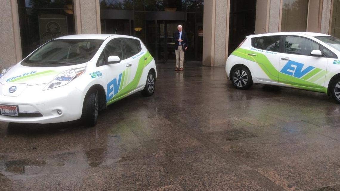 Ken Miller of the Snake River Alliance arrives at Idaho Power headquarters for the company's 101st annual meeting with two of its electric cars sitting outside.