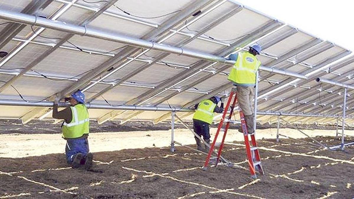 Workers install a solar project in Massachusetts.