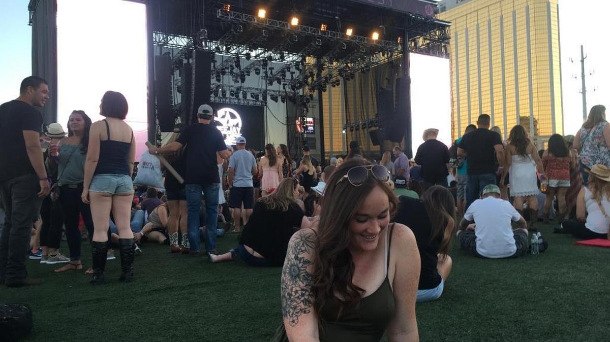 Ryenne Clancy sits on the grass at the Route 91 Harvest Festival in Las Vegas, Nev. The Boise State junior is trying to return to her normal routine one week after she witnessed a mass shooting at the country music gathering.