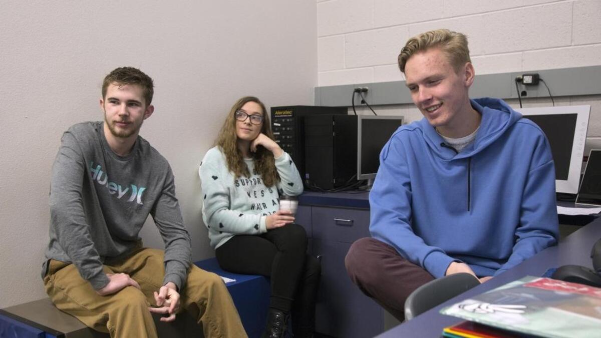 Aiden Holcroft, left, Alexa Adams and Declan Tomlinson, part of a team of broadcasting and video students at Eagle High School, start their school day re-editing a long version of “The Teal Chair.” Said Holcroft: “As somebody who’s younger and a filmmaker, death is such a different kind of subject.”
