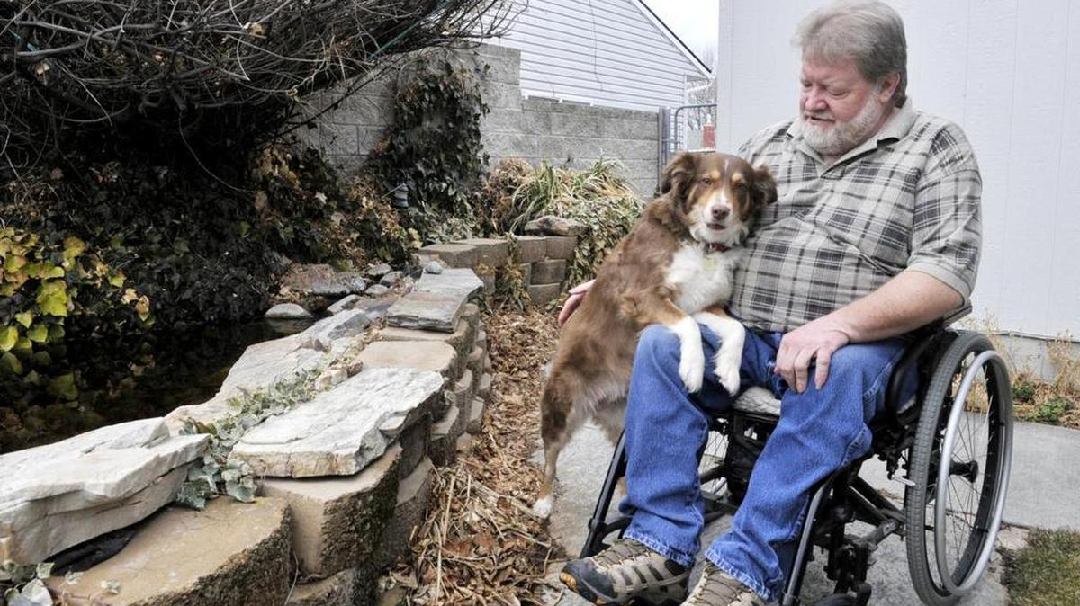 Milo Hatt and his dog, Daisy, outside their home in Rupert. Hatt broke his back in a dirt bike accident at the age of 28, paralyzing him from the chest down.