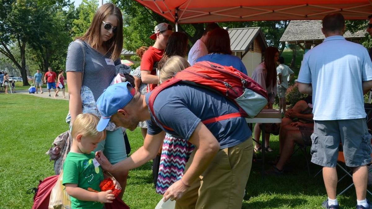 Carlen Smith puts a nametag on his son, Isaac, as the family arrives to the Covenant of Christ Conference at Eagle Island State Park on Saturday, Sept. 2.