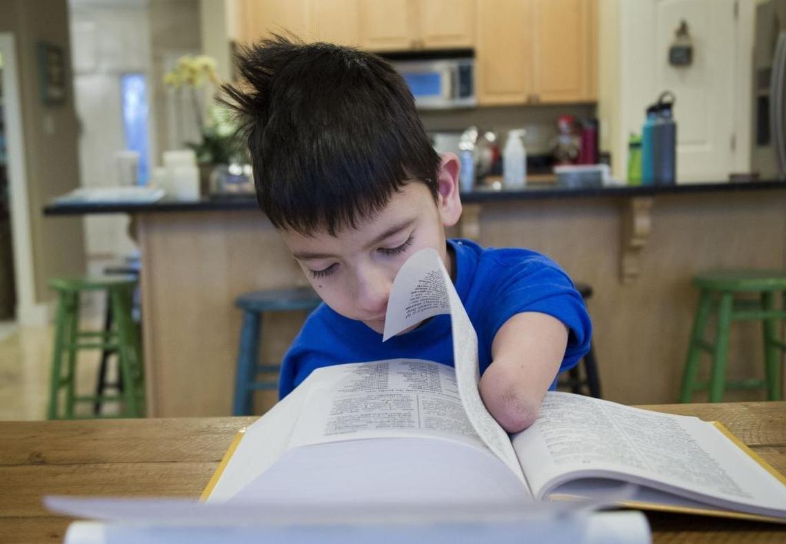 Bowen Toomey, 9, is obsessed with dictionaries. He has 15 of them. “I like the definitions,” he says. At the kitchen table, he works on vocabulary words.