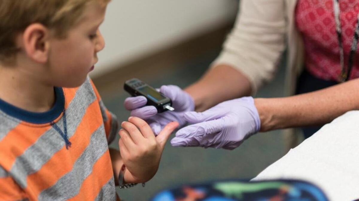 Falmouth (Maine) Elementary first-grader Owen Pollard, 6, has his blood sugar carbohydrate levels checked by Kellie Schimelman, a nurse who can administer insulin if needed, at the school.