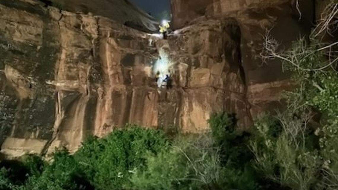 A climber dangled from a canyon cliff during an intense storm in Utah after her hair got tangled in her rappelling gear, dramatic photos show.