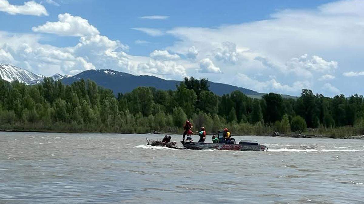 A family float turned perilous when the raft caught on a downed tree in the middle of a raging river in Wyoming near Grand Teton National Park, officials said.