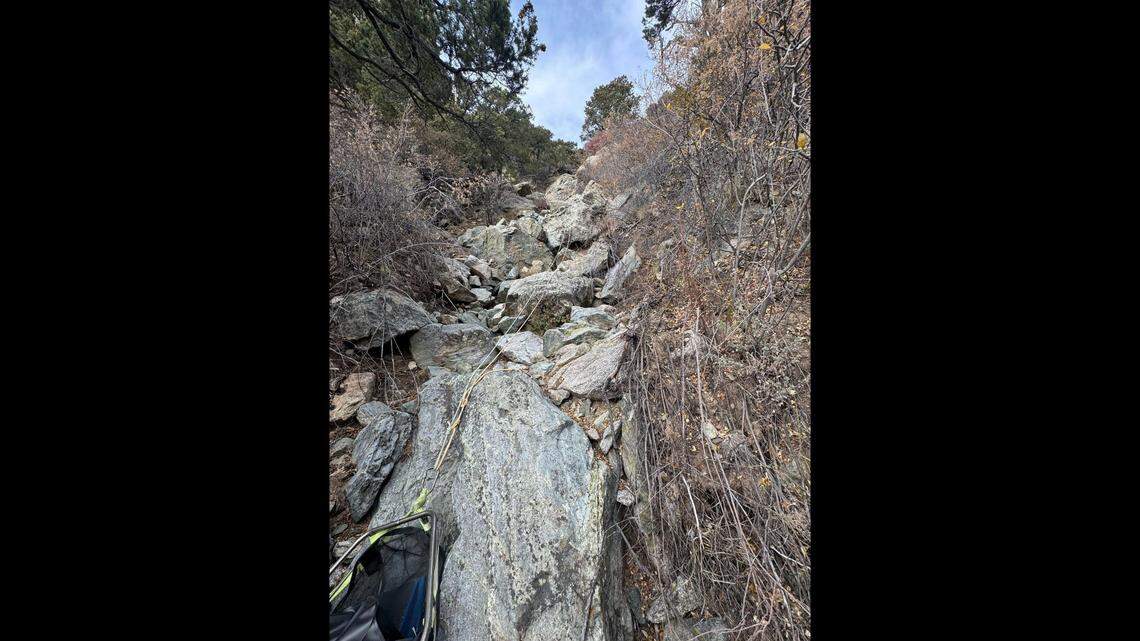 A photo shows the rope system set up over jagged rocks piled over a downhill slope.