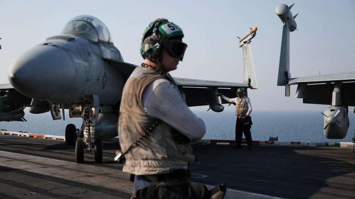 Flight deck crew members stand next to a fighter jet in preparation for its launch on the USS Theodore Roosevelt while under way in the Arabian Gulf, Aug. 6, 2015. The Obama administration has become locked in a sharp new debate over whether to deploy American military forces to establish no-fly zones and safe havens in Syria to protect civilians caught in the grinding civil war.