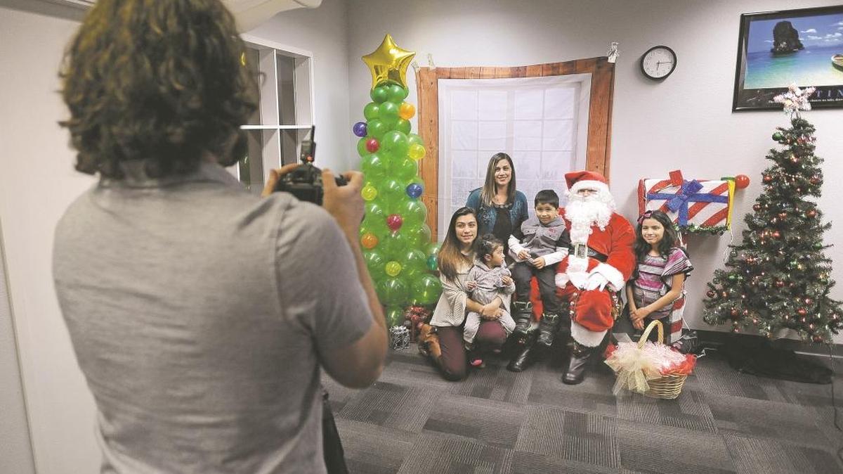 Dayne Dingman photographs the Pineda family Wednesday in Idaho Falls. Clandestine Kringle offered free pictures with Santa for children who couldn’t otherwise get one. Marci Pineda’s family already had recieved a Clandestine Kringle delivery made by Dingman. “We’ve been very blessed,” she said. “They came to see us a week ago. We’ve been overwhelmed with their generosity.”