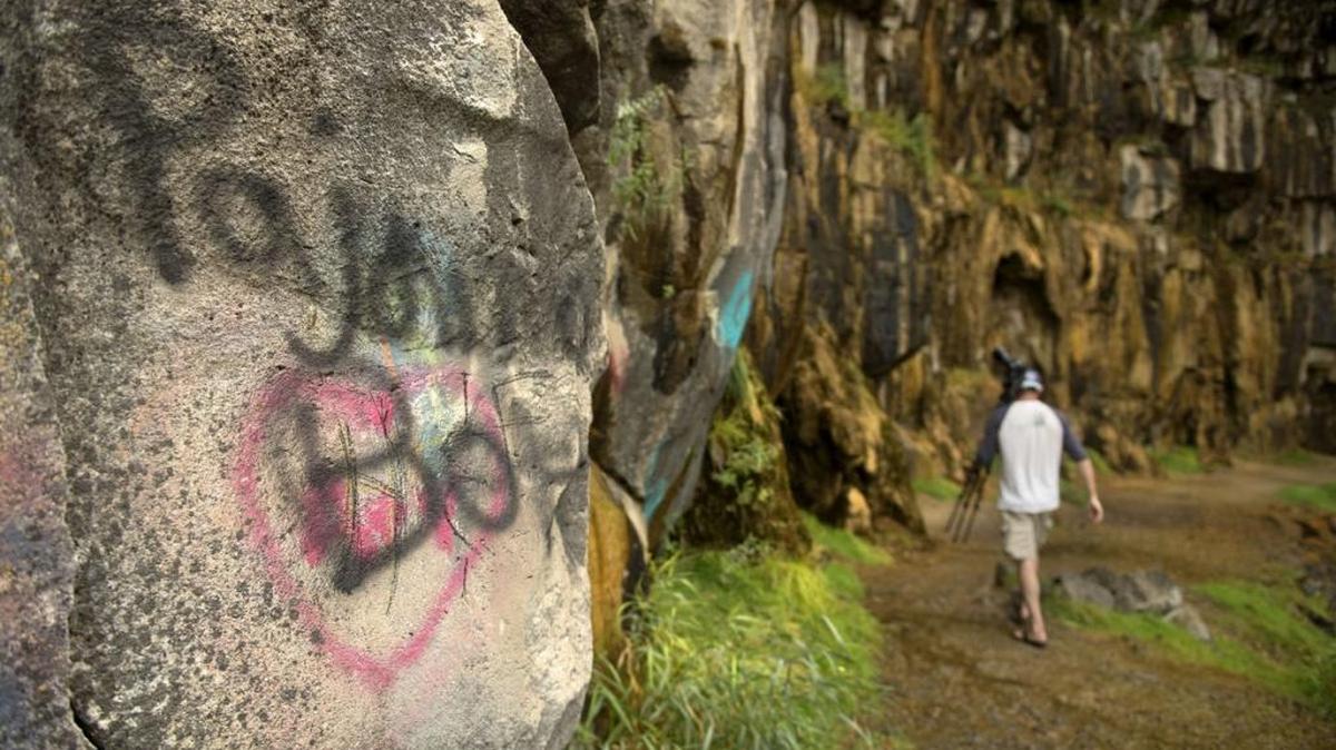 Brian Puyear takes pictures and explore the Perrine Coulee waterfall Monday, Aug. 14, 2017, along Canyon Springs Road in Twin Falls. A tourist stop for years, the canyon has had a rash of tagging in recent months.