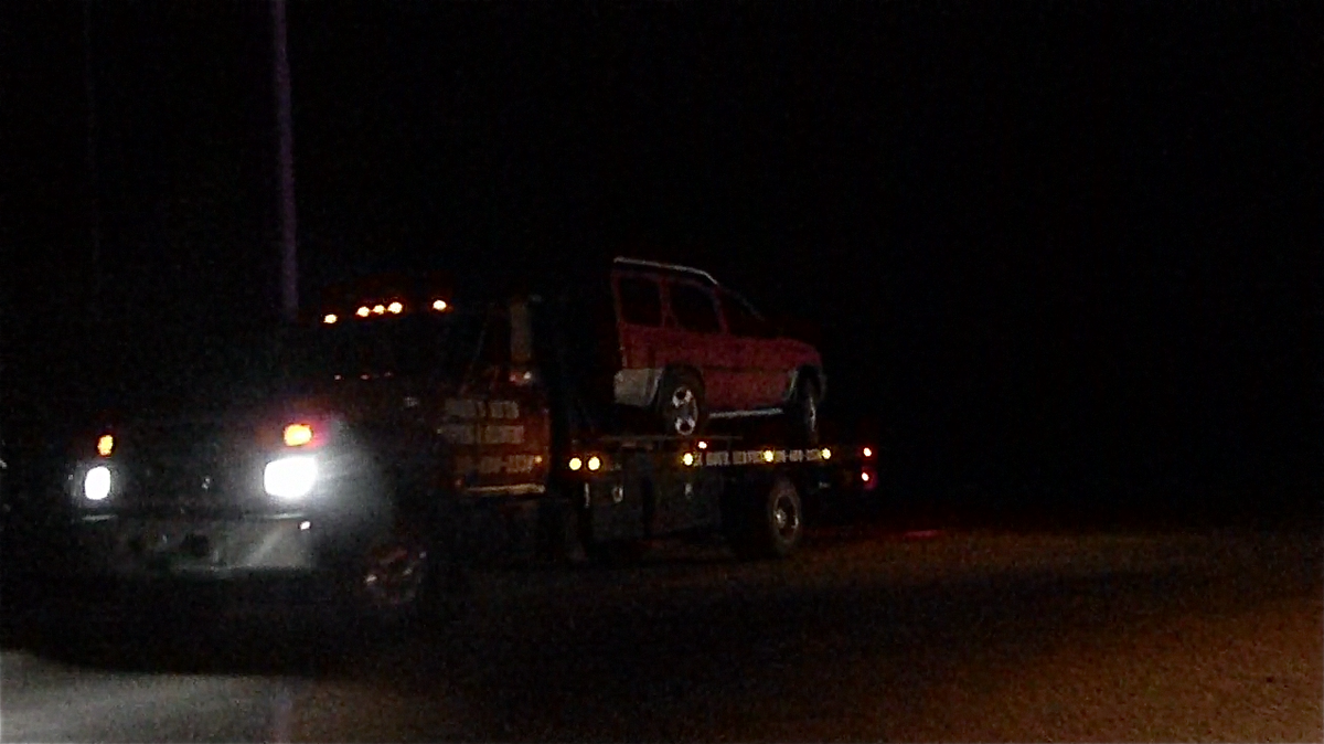 A tow truck hauls away a vehicle that went into a pond north of Blackfoot on Monday night.