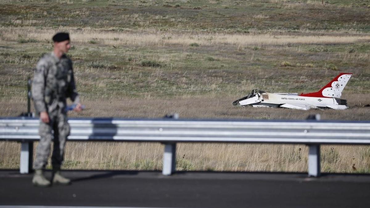 An Air Force security officer guards the site where a U.S. Air Force Thunderbird crashed after a flyover performance at a commencement for Air Force Academy cadets, south of Colorado Springs, Colo., on Thursday.
