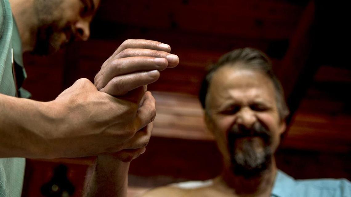 Coeur d’Alene pastor Tim Remington grimaces in pain during physical therapy at his home April 28. Remington was shot eight times as he was leaving the Altar Church on Sunday, March 6.